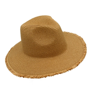 Detail of hand-woven straw hat showing raw fringe edge and natural raffia texture
