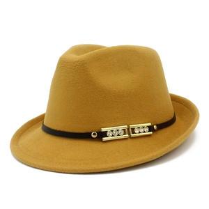 Close-up of mustard wool fedora featuring a black band with gold buckle and rhinestones