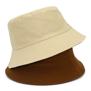 Détail de bobs en coton réversibles beige et marron avec coutures précises sur le bord