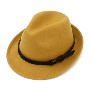 Close-up of mustard yellow wool fedora hat with a black band and gold buckle detail