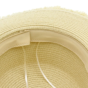 Detail of woven straw sun hat showing adjustable drawstring and natural frayed edge