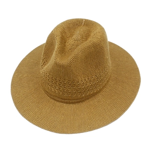 Detail view of woven straw sun hat texture and stylish indented fedora crown design