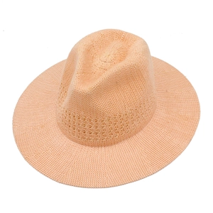 Detailed macro view of high-quality hand-woven straw hat texture in soft peach hue