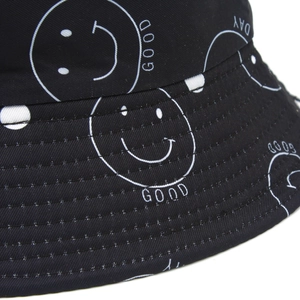Détail macro d'un chapeau bob noir avec smiley blanc et coutures de bordure renforcées