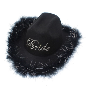 Detailed view of black bride cowboy hat with rhinestone lettering and feather trim