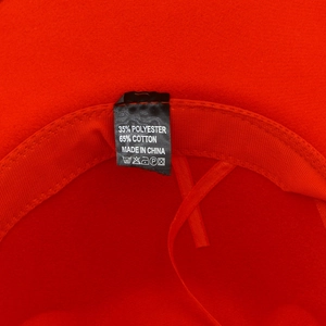 Detail of red cowboy hat interior showing sweatband and 65% cotton fabric label
