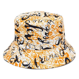 Détail du chapeau bob graffiti avec motifs tourbillon orange et écritures artistiques noires