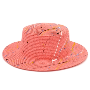 Detail of coral pink boater hat with colorful artistic paint splatter texture
