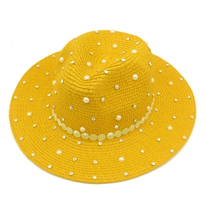 Detail of yellow straw hat featuring elegant pearls, rhinestones, and sequin trim decoration