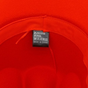 Macro shot of red felt hat interior showing 65% polyester 35% wool label and sweatband