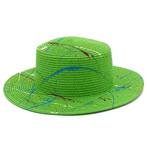 Green straw Panama hat with colorful graffiti paint splatters and wide brim for beach sun protection