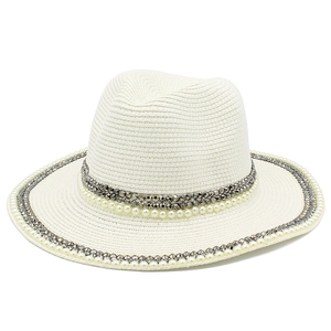 Close-up of white straw Fedora hat featuring elegant pearl and grey beaded trim details