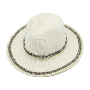 Close-up of woven straw hat featuring elegant pearl and metal stud decorative bands