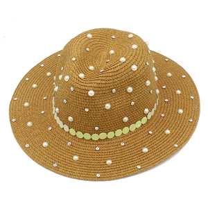 Detail of straw boater hat featuring rows of faux pearls and sparkling rhinestones