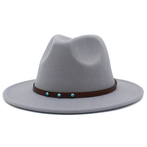Détail d'un chapeau fedora gris clair avec ruban en cuir brun et clous turquoise