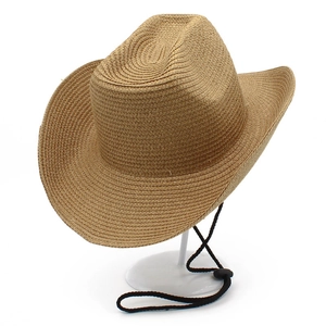 Detail of a foldable straw cowboy hat featuring woven texture and adjustable chin strap