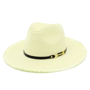 Détail d'un chapeau de paille à bords effilochés avec ruban noir et boucle dorée sur blanc