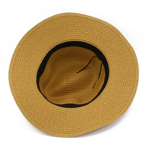 Detail view of woven straw hat interior featuring black sweatband and adjustable drawstring