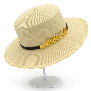 Detail of boater hat with gold leaf charm, black leather band, and fringe brim