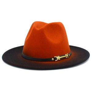 Detail eines Fedora-Hutes mit orange-schwarzem Farbverlauf, Lederband und goldener Schnalle