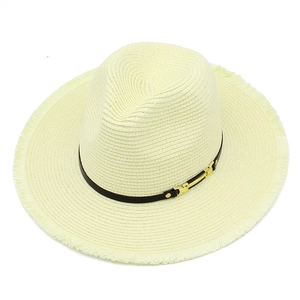 Détail d'un chapeau de paille crème avec bande en cuir marron et bordure à franges
