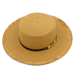 Dettaglio cappello di paglia con tesa a frange e cinturino in pelle con fibbia oro