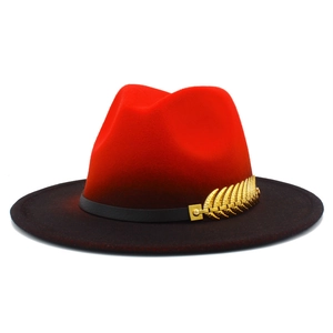 Detail of red and black gradient fedora with leather band and golden feather pin