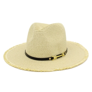 Détail d'un chapeau de paille aux bords effilochés avec ruban en cuir marron et boucle