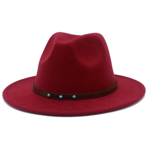 Détail d'un chapeau fedora rouge foncé avec ruban en cuir et ornements en turquoise