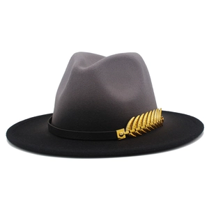 Detail of grey and black gradient wool fedora with gold metal feather and leather band