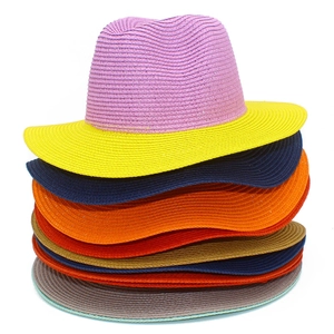 Detailed stack of multi-colored woven straw Panama hats showing vibrant texture and brim layers