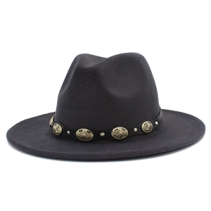Detalle de sombrero fedora gris oscuro con banda de cuero y adornos de metal vintage