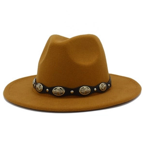 Detalle de tachuelas metálicas plateadas en la banda de cuero negro del sombrero fedora camel