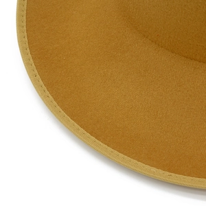 Detailed macro view of camel felt fedora brim with premium reinforced stitched edging