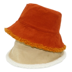 Detalle de sombreros bucket de pana con ribete de felpa en tonos naranja y beige