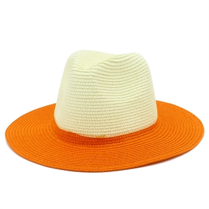 Close-up of woven straw texture on beige and orange wide-brim Panama sun hat