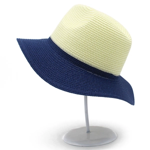 Close-up of two-tone beige and navy straw Panama hat featuring a wide brim and ribbon