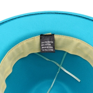 Detalle del interior del sombrero de fieltro azul con banda y etiqueta de tela