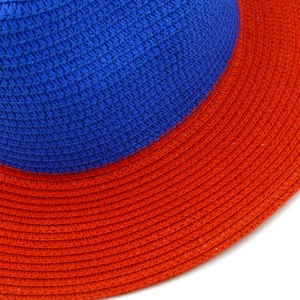 Close-up of dual-color woven straw hat showing detailed royal blue and orange red textures