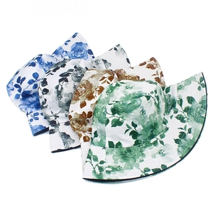 Detailed view of sun hats in blue, gray, and green featuring ink flower print patterns