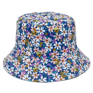 Detail view of small floral patterns on navy blue fabric of this reversible bucket hat