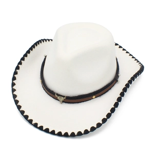 Detalle de sombrero vaquero de fieltro blanco con banda de cuero y emblema de cráneo de toro