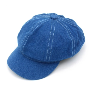 Detailed close-up of dark blue denim baker boy hat with contrast white stitching