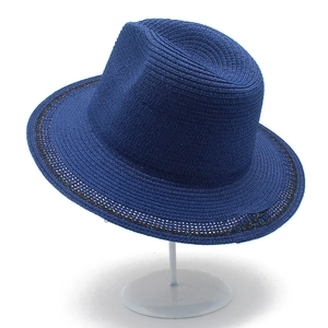 Detail view of navy blue woven straw fedora hat featuring delicate openwork brim design
