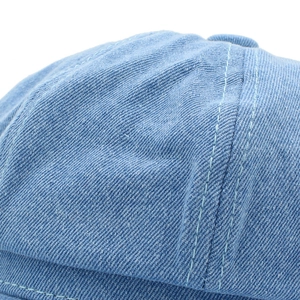Close-up of light blue denim octagonal cap showing premium denim twill and double stitching