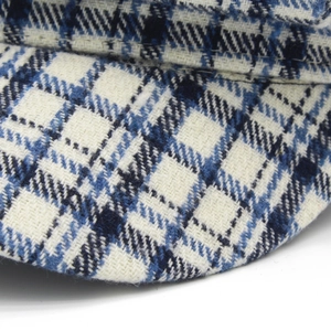 Detalle del tejido de cuadros azules y blancos de una gorra de lana de estilo británico