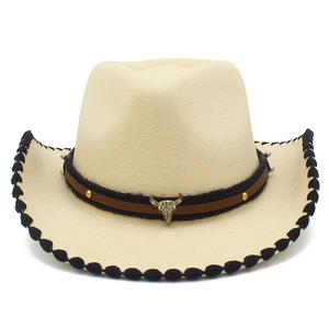 Detalle de sombrero vaquero con borde de costura negra y adorno metálico de cráneo de toro