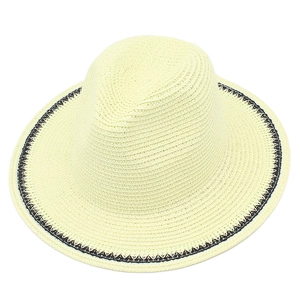 Detailed close-up of cream straw sun hat with spiral weave and black-white decorative trim