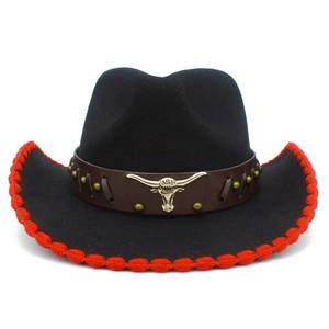 Detalle de sombrero vaquero con borde trenzado rojo y emblema de cabeza de toro dorada