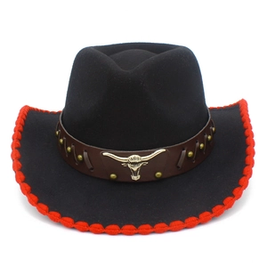 Detalle de sombrero vaquero negro con borde trenzado rojo y emblema de cabeza de toro